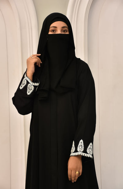 Women with black color embroidered abaya and black niqab