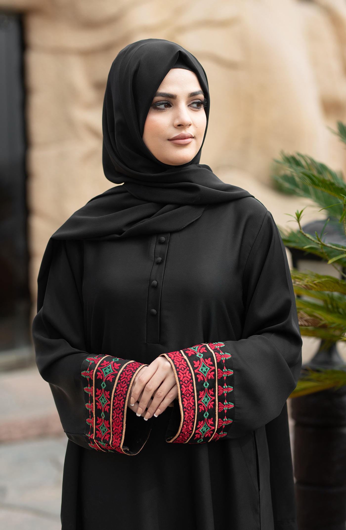 black front closed abaya with red embroidered sleeves and side pockets