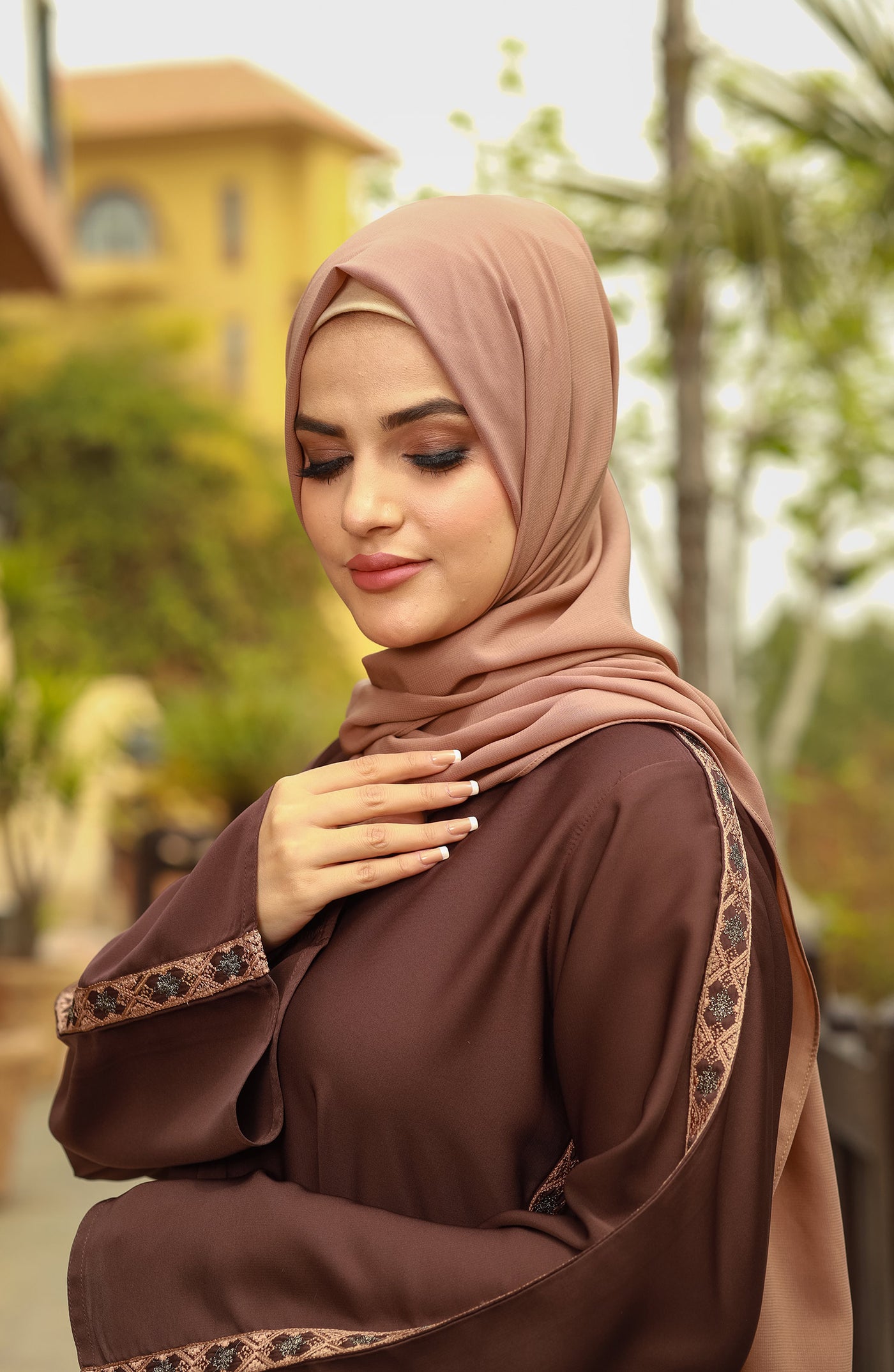 women with brown embroidered abaya & hijab