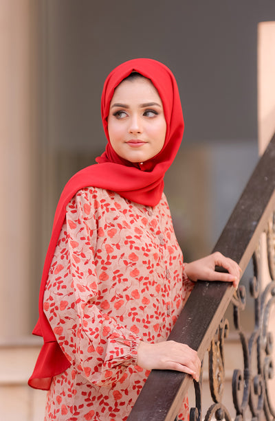 lady with red scarf and beige co-ords with red florals