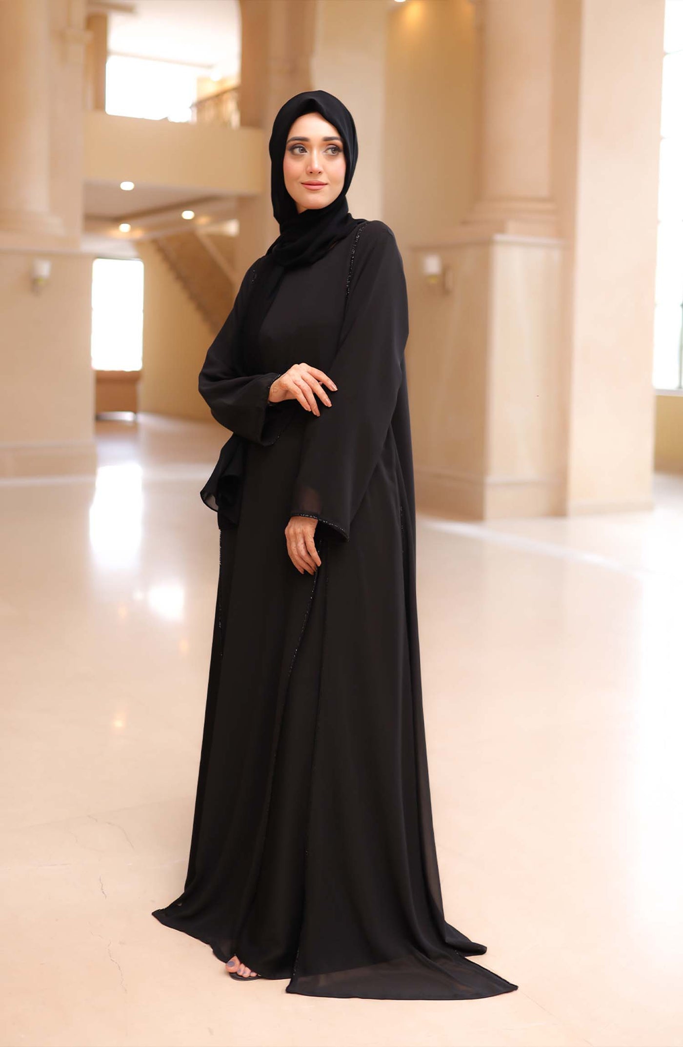  Stylish black abaya in traditional Arabic design, perfect for any formal occasion. 